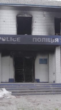 Bu dikey video Ukrayna 'daki savaşın sonucunu gösteriyor. Borodyanka, Kyiv bölgesindeki polis karakolunun yıkılmış ve yanmış binası. Gri, renksiz, düz.