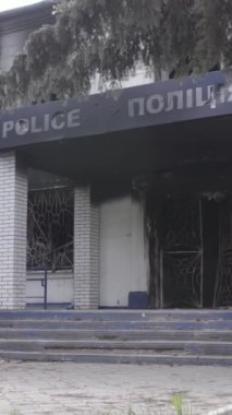 Bu dikey video Ukrayna 'daki savaşın sonucunu gösteriyor. Borodyanka, Kyiv bölgesindeki polis karakolunun yıkılmış ve yanmış binası. Gri, renksiz, düz.