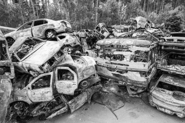 Bu siyah-beyaz fotoğraf Irpin, Bucha bölgesinde bir kurşun ve yanmış araba çöplüğünü gösteriyor.