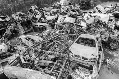 Bu siyah-beyaz fotoğraf Irpin, Bucha bölgesinde bir kurşun ve yanmış araba çöplüğünü gösteriyor.