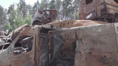 Bu video Irpin, Bucha bölgesinde, gri, düz, renksiz, yanmış arabaları gösteriyor.