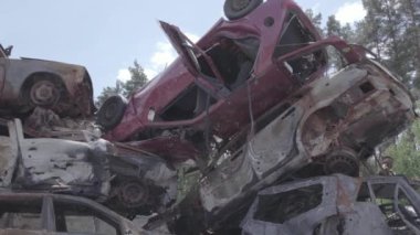 Bu video Irpin, Bucha bölgesinde, gri, düz, renksiz, yanmış arabaları gösteriyor.