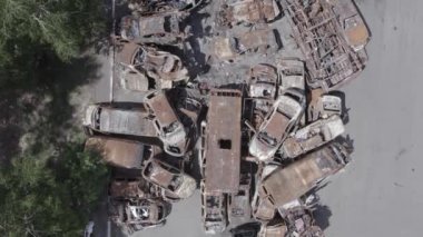 Bu video Irpin, Bucha bölgesinde, gri, düz, renksiz, yanmış arabaları gösteriyor.