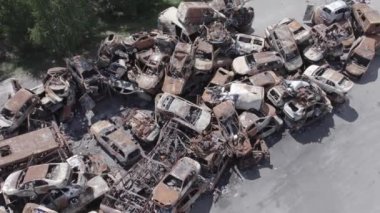 Bu video Irpin, Bucha bölgesinde, gri, düz, renksiz, yanmış arabaları gösteriyor.