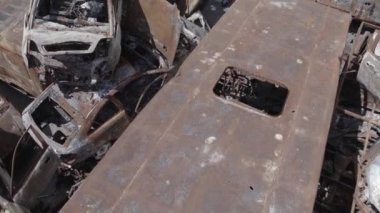 Bu video Irpin, Bucha bölgesinde, gri, düz, renksiz, yanmış arabaları gösteriyor.