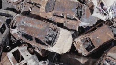 Bu video Irpin, Bucha bölgesinde, gri, düz, renksiz, yanmış arabaları gösteriyor.