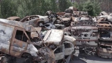 Bu video Irpin, Bucha bölgesinde, gri, düz, renksiz, yanmış arabaları gösteriyor.