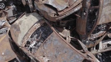 Bu video Irpin, Bucha bölgesinde, gri, düz, renksiz, yanmış arabaları gösteriyor.