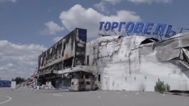 Bu video, Bucha 'daki bir alışveriş merkezinin yıkık dökük bir binasını gösteriyor. Ağır çekimde, gri, düz.
