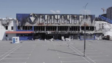 Bu video, Bucha 'daki bir alışveriş merkezinin yıkık dökük bir binasını gösteriyor. Ağır çekimde, gri, düz.