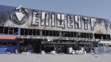 Bu video, Bucha 'daki bir alışveriş merkezinin yıkık dökük bir binasını gösteriyor. Ağır çekimde, gri, düz.