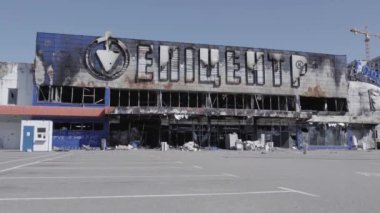 Bu video, Bucha 'daki bir alışveriş merkezinin yıkık dökük bir binasını gösteriyor. Ağır çekimde, gri, düz.