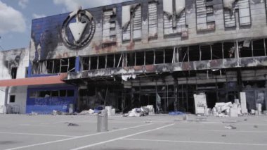 Bu video, Bucha 'daki bir alışveriş merkezinin yıkık dökük bir binasını gösteriyor. Ağır çekimde, gri, düz.