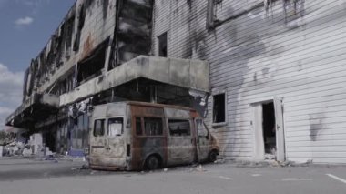 Bu video, Bucha 'daki bir alışveriş merkezinin yıkık dökük bir binasını gösteriyor. Ağır çekimde, gri, düz.