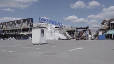 Bu video, Bucha 'daki bir alışveriş merkezinin yıkık dökük bir binasını gösteriyor. Ağır çekimde, gri, düz.