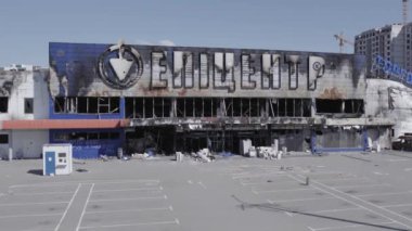 Bu video, Bucha 'daki bir alışveriş merkezinin yıkık dökük bir binasını gösteriyor. Ağır çekimde, gri, düz.