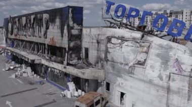 Bu video, Bucha 'daki bir alışveriş merkezinin yıkık dökük bir binasını gösteriyor. Ağır çekimde, gri, düz.