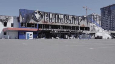 Bu video, Bucha 'daki bir alışveriş merkezinin yıkık dökük bir binasını gösteriyor. Ağır çekimde, gri, düz.