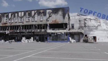 Bu video, Bucha 'daki bir alışveriş merkezinin yıkık dökük bir binasını gösteriyor. Ağır çekimde, gri, düz.
