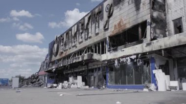 Bu video, Bucha 'daki bir alışveriş merkezinin yıkık dökük bir binasını gösteriyor. Ağır çekimde, gri, düz.