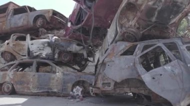 Bu video Ukrayna 'daki savaşın sonucunu gösteriyor. Yakılmış ve vurulmuş arabalar, gri, renksiz, düz.