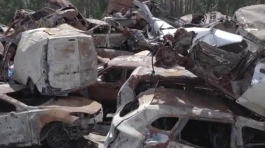 Bu video Ukrayna 'daki savaşın sonucunu gösteriyor. Yakılmış ve vurulmuş arabalar, gri, renksiz, düz.