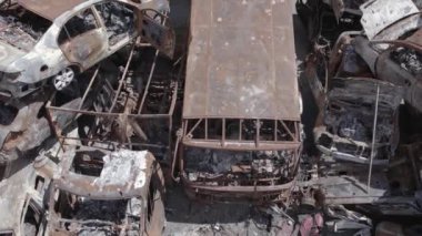 Bu video Ukrayna 'daki savaşın sonucunu gösteriyor. Yakılmış ve vurulmuş arabalar, gri, renksiz, düz.