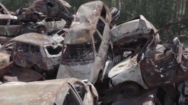 Bu video Ukrayna 'daki savaşın sonucunu gösteriyor. Yakılmış ve vurulmuş arabalar, gri, renksiz, düz.