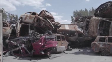 Bu video Ukrayna 'daki savaşın sonucunu gösteriyor. Yakılmış ve vurulmuş arabalar, gri, renksiz, düz.