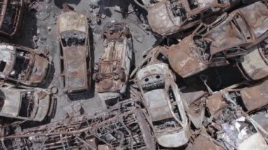 Bu video Ukrayna 'daki savaşın sonucunu gösteriyor. Yakılmış ve vurulmuş arabalar, gri, renksiz, düz.