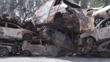 Bu video Ukrayna 'daki savaşın sonucunu gösteriyor. Yakılmış ve vurulmuş arabalar, gri, renksiz, düz.