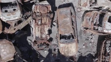 Bu video Ukrayna 'daki savaşın sonucunu gösteriyor. Yakılmış ve vurulmuş arabalar, gri, renksiz, düz.