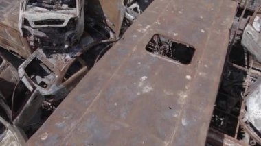 Bu video Ukrayna 'daki savaşın sonucunu gösteriyor. Yakılmış ve vurulmuş arabalar, gri, renksiz, düz.