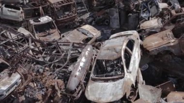 Bu video Ukrayna 'daki savaşın sonucunu gösteriyor. Yakılmış ve vurulmuş arabalar, gri, renksiz, düz.