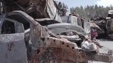 Bu video Ukrayna 'daki savaşın sonucunu gösteriyor. Yakılmış ve vurulmuş arabalar, gri, renksiz, düz.