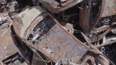 Bu video Ukrayna 'daki savaşın sonucunu gösteriyor. Yakılmış ve vurulmuş arabalar, gri, renksiz, düz.