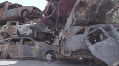 Bu video Ukrayna 'daki savaşın sonucunu gösteriyor. Yakılmış ve vurulmuş arabalar, gri, renksiz, düz.