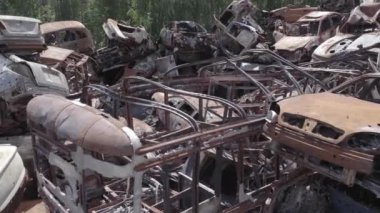 Bu video Ukrayna 'daki savaşın sonucunu gösteriyor. Yakılmış ve vurulmuş arabalar, gri, renksiz, düz.