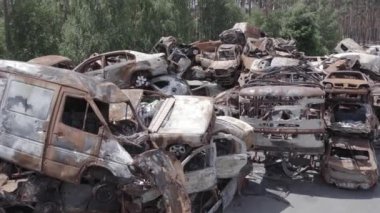 Bu video Ukrayna 'daki savaşın sonucunu gösteriyor. Yakılmış ve vurulmuş arabalar, gri, renksiz, düz.