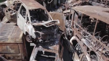 Bu video Ukrayna 'daki savaşın sonucunu gösteriyor. Yakılmış ve vurulmuş arabalar, gri, renksiz, düz.