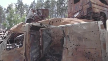 Bu video Ukrayna 'daki savaşın sonucunu gösteriyor. Yakılmış ve vurulmuş arabalar, gri, renksiz, düz.