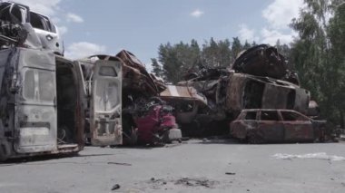Bu video Ukrayna 'daki savaşın sonucunu gösteriyor. Yakılmış ve vurulmuş arabalar, gri, renksiz, düz.