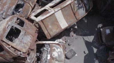 Bu video Ukrayna 'daki savaşın sonucunu gösteriyor. Yakılmış ve vurulmuş arabalar, gri, renksiz, düz.