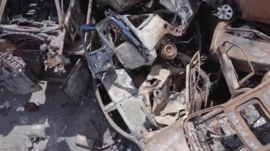 Bu video Ukrayna 'daki savaşın sonucunu gösteriyor. Yakılmış ve vurulmuş arabalar, gri, renksiz, düz.