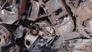 Bu video Ukrayna 'daki savaşın sonucunu gösteriyor. Yakılmış ve vurulmuş arabalar, gri, renksiz, düz.