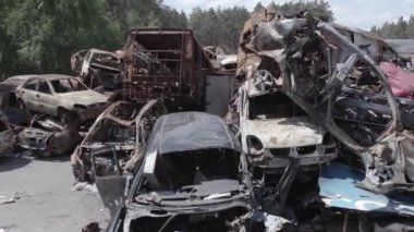 Bu video Ukrayna 'daki savaşın sonucunu gösteriyor. Yakılmış ve vurulmuş arabalar, gri, renksiz, düz.