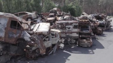 Bu video Ukrayna 'daki savaşın sonucunu gösteriyor. Yakılmış ve vurulmuş arabalar, gri, renksiz, düz.