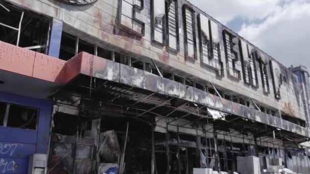 この株式ビデオは 戦争中にウクライナのブチャにショッピングセンターの破壊された建物を示しています グレー 色はありません フラット — ストック動画