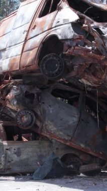 Bu stok dikey video Irpin, Bucha bölgesinde bir kurşun ve yanmış araba dökümü gösteriyor.