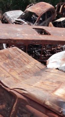 Bu stok dikey video Irpin, Bucha bölgesinde bir kurşun ve yanmış araba dökümü gösteriyor.